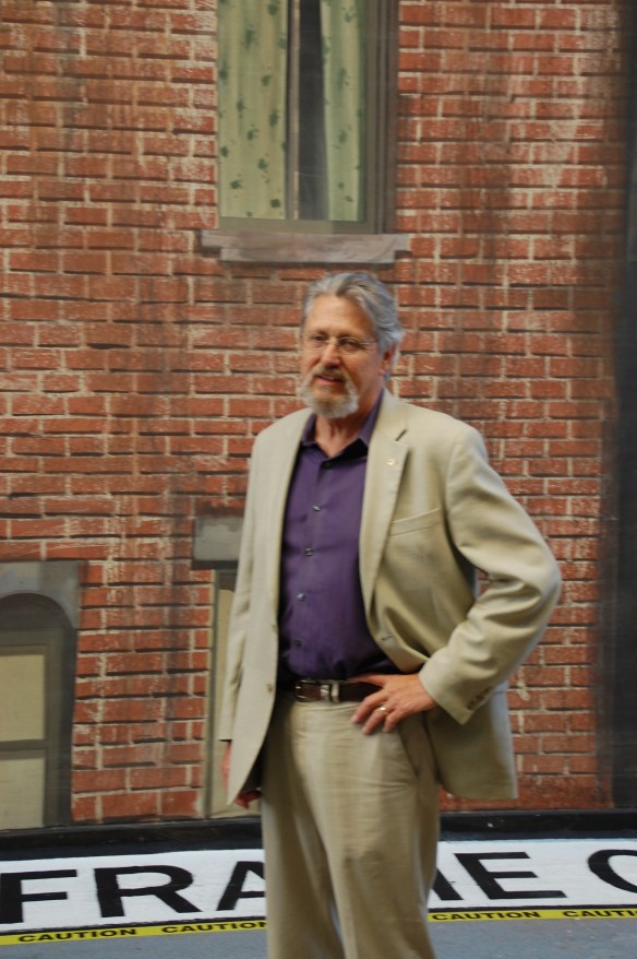 Art Directors Guild's Associate Executive Director John Moffit in front of one of the many backings he painted while Head of the Scenic Department at Warner Bros. Studio